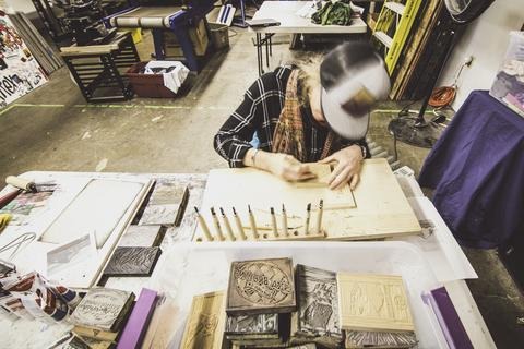 Anneka working in the Recaps Studio hand carving a block print